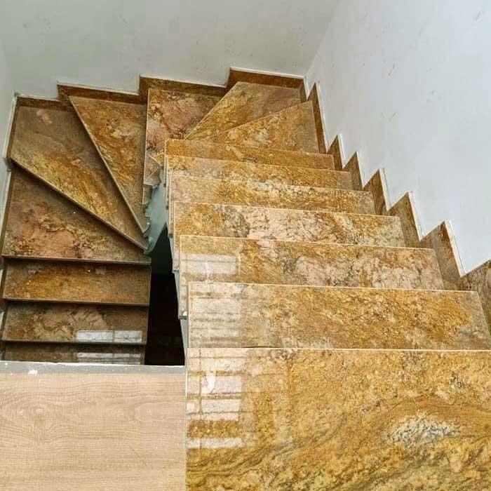 Cầu thang ốp đá đen kết hợp tay vịn gỗ tạo vẻ đẹp ấm cúng và sang trọng