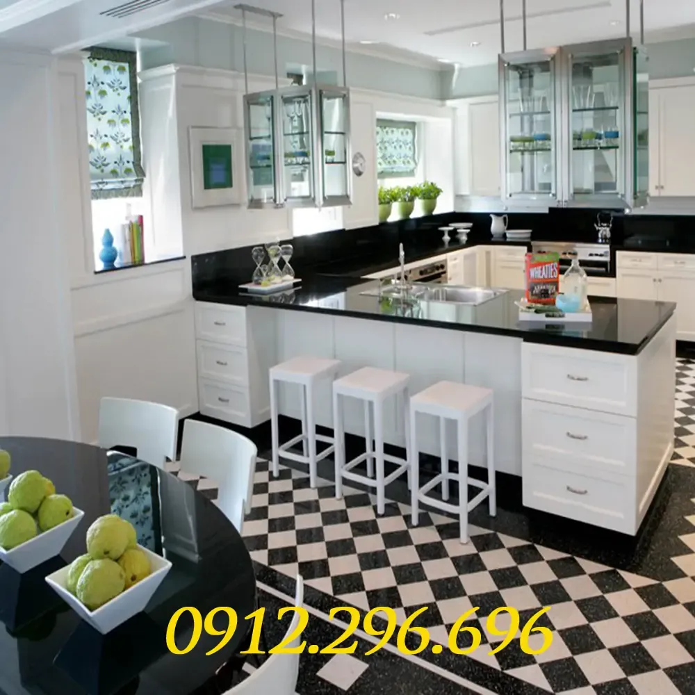 Người phụ nữ đang lau chùi bề mặt đá hoa cương bếp sáng bóng